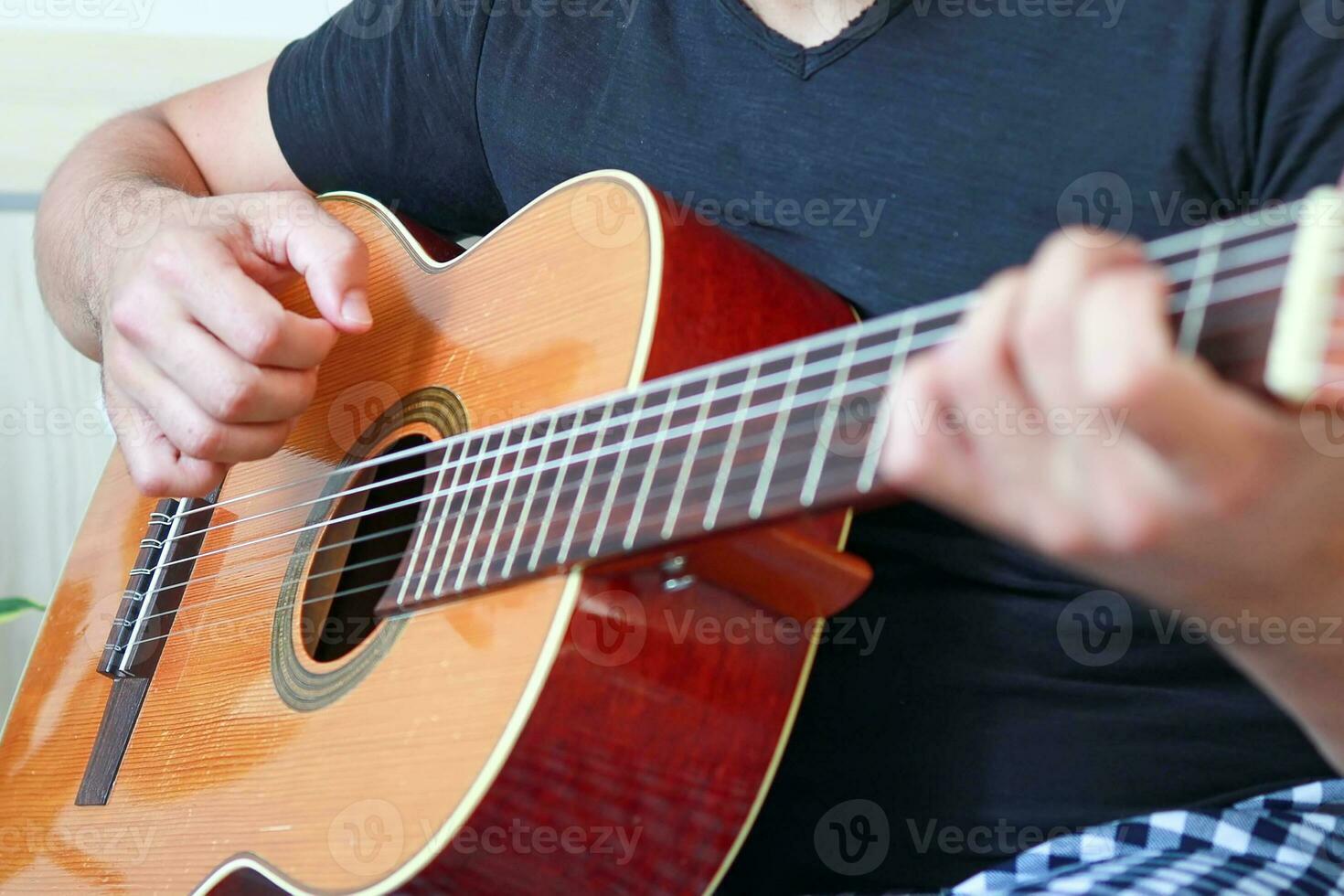 närbild av manlig händer spelar akustisk gitarr foto