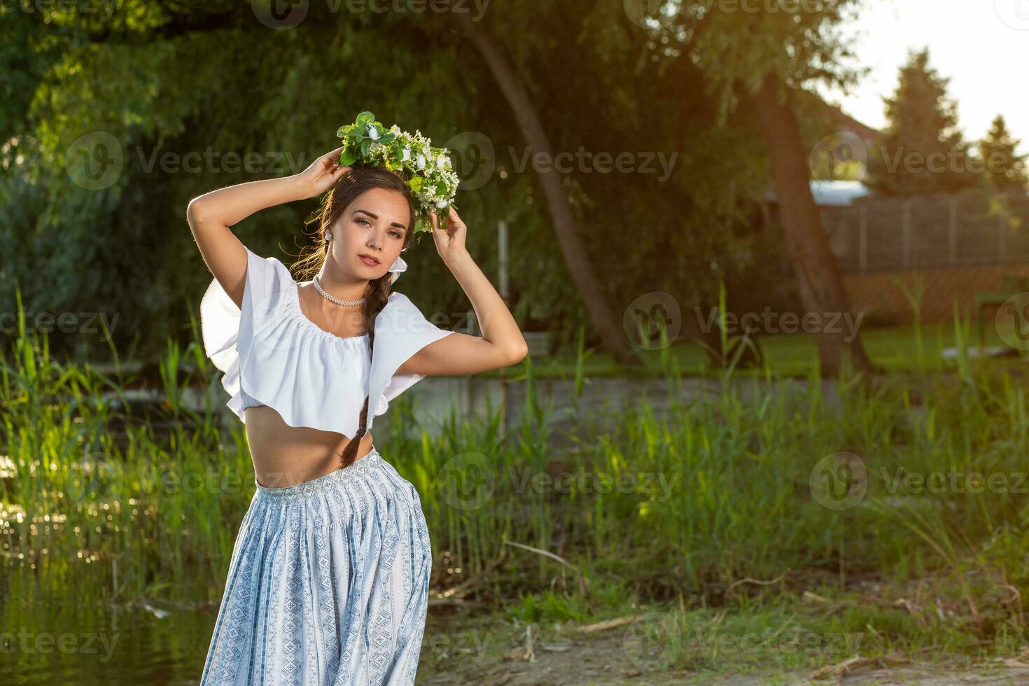 ung skön caucasian kvinna stående på de Bank av flod. traditionell landsbygden bild med flicka på förgrund och kopia Plats. foto