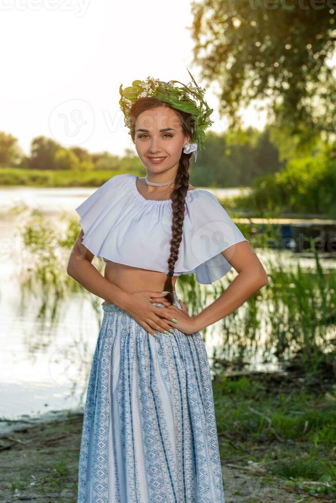 ung skön caucasian kvinna stående på de Bank av flod. traditionell landsbygden bild med flicka på förgrund och kopia Plats. foto