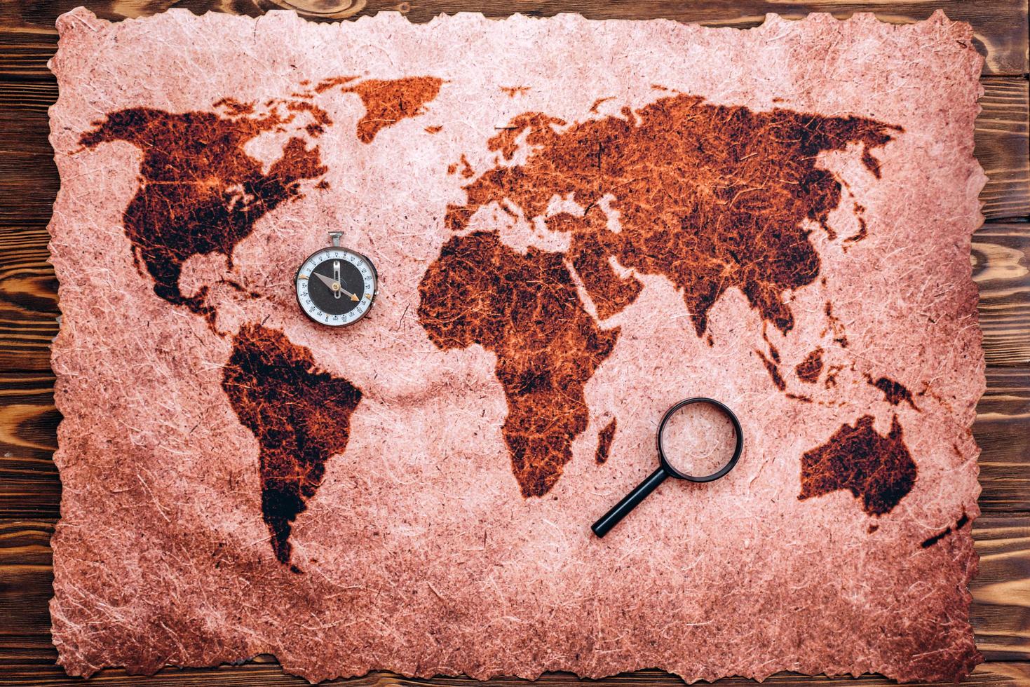en världskarta läggs ut på ett träbord foto
