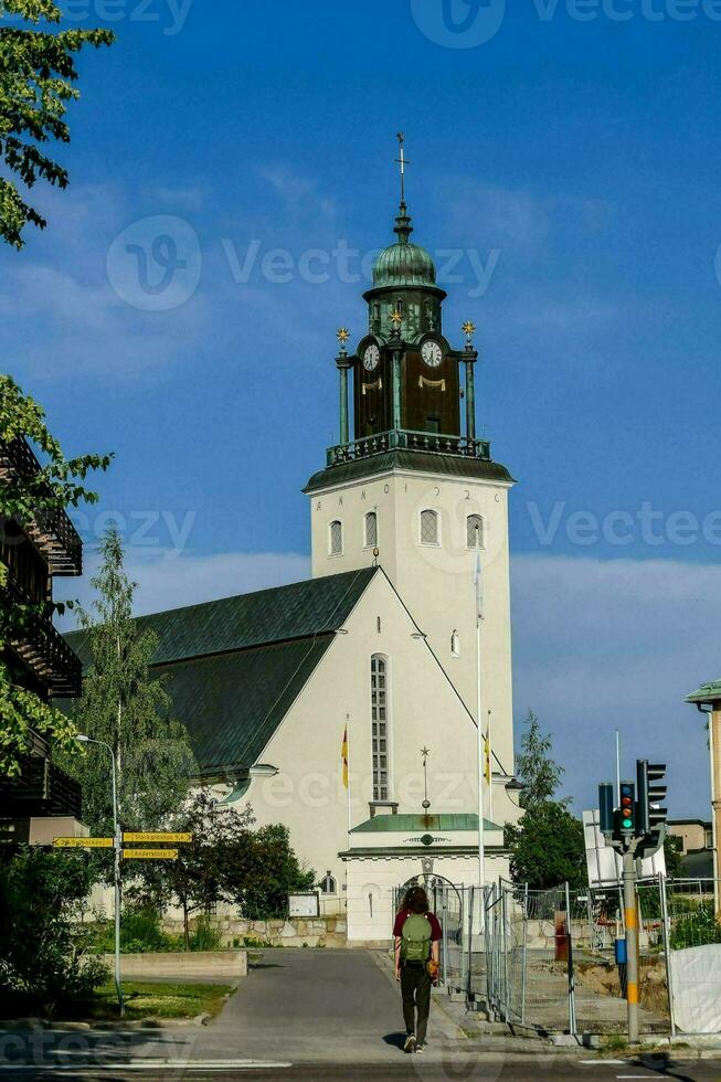 en kyrka med en klocka torn på de sida foto