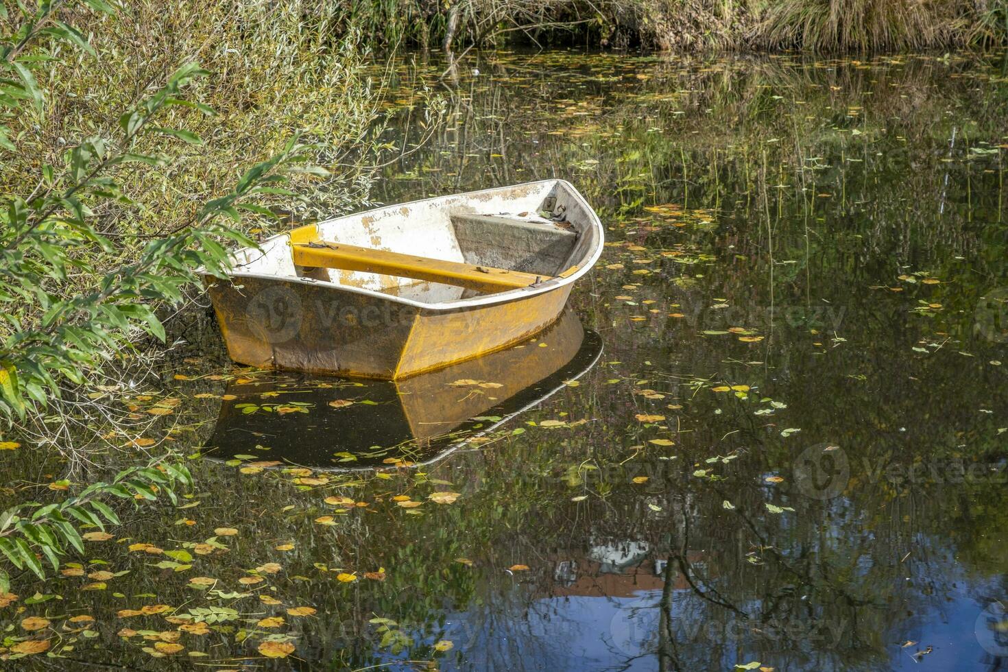 detta foton visar en båt på en små damm med reflektioner i en jordbrukare by i Tyskland