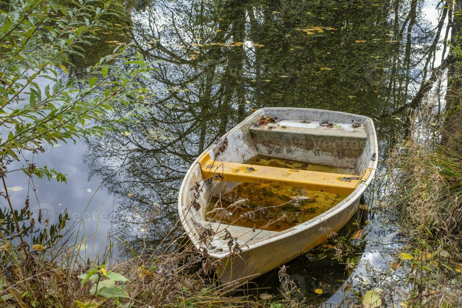 detta foton visar en båt på en små damm med reflektioner i en jordbrukare by i Tyskland