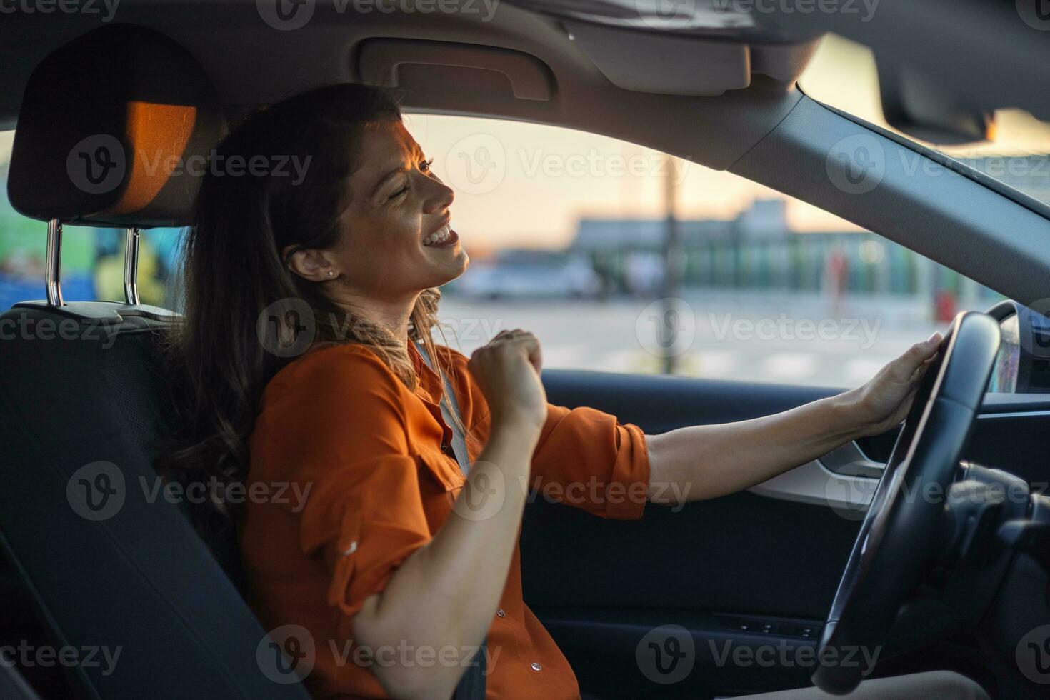 Foto av positiv glad flicka rida kör bil stad rutt vänta trafik sylt lyssna, musik ljud Prova dansa känna upphetsad