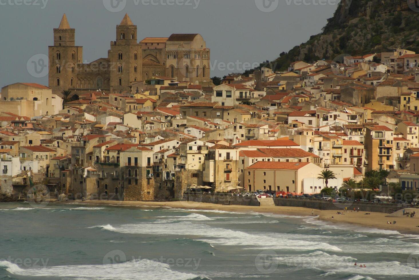 hus längs de strandlinje och katedral i bakgrund, cefalu, sicilien foto