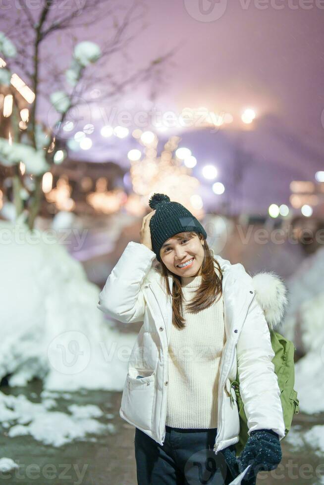 kvinna turist sightseeing i niseko stad med snö i vinter- säsong. landmärke och populär för attraktioner i Hokkaido, japan. resa och semester begrepp foto