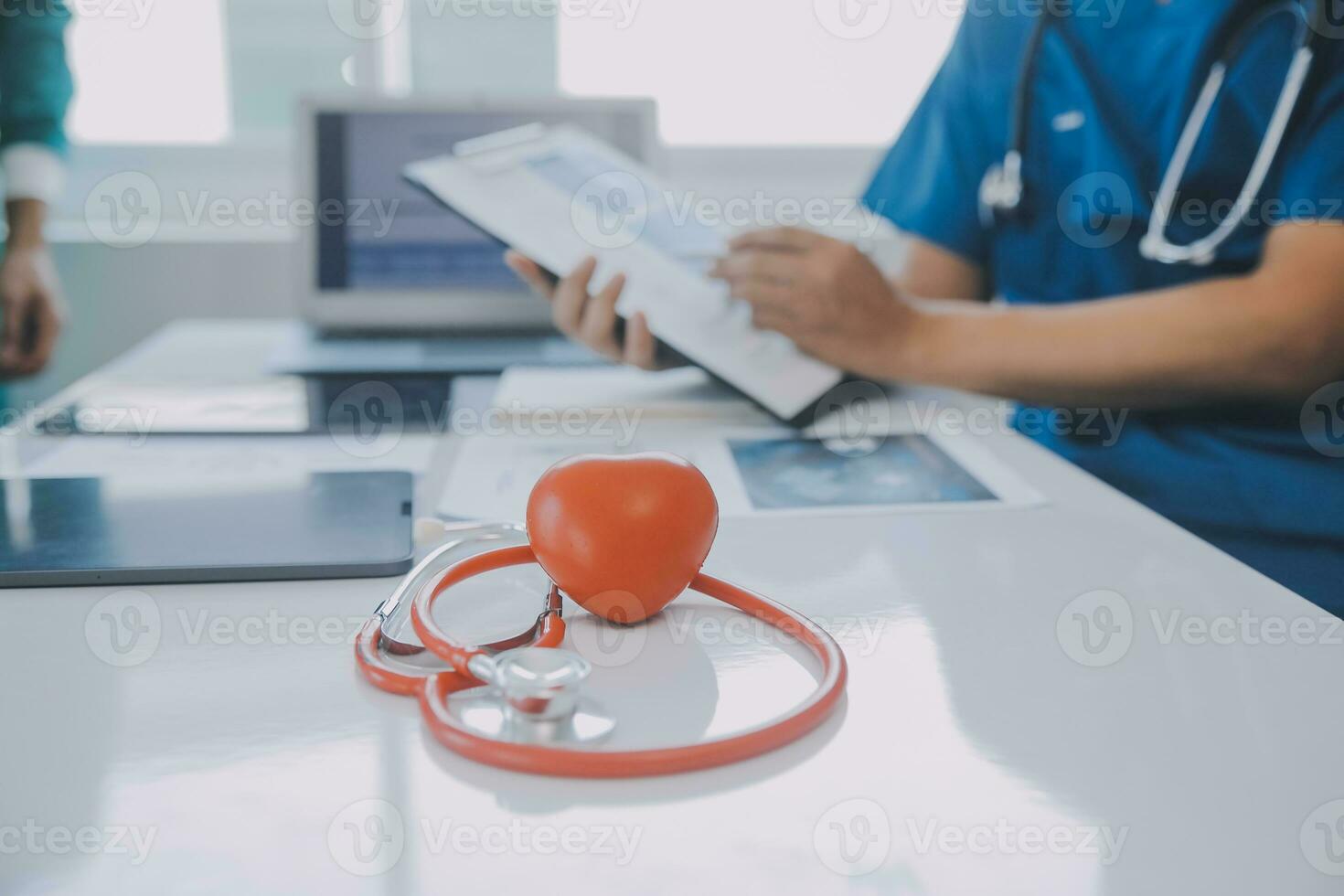 raser team av doktorer diskuterar en patient stående grupperade i de foyer ser på en läsplatta dator, stänga upp se foto