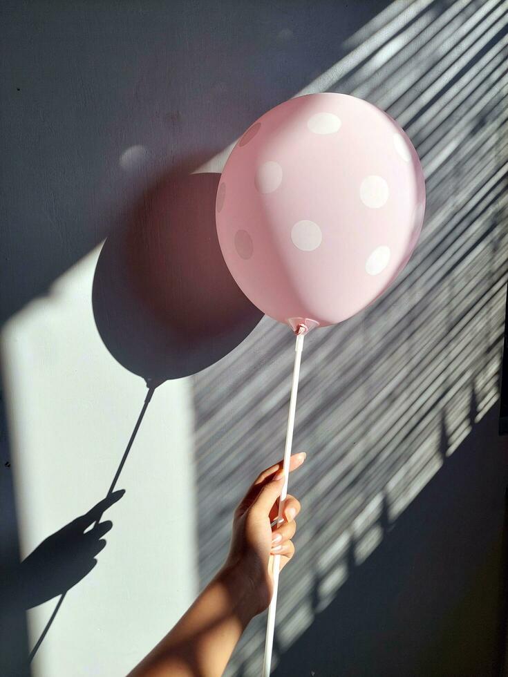 Lycklig barn innehav färgrik ballong, fira med vänner, med skugga och ljus foto