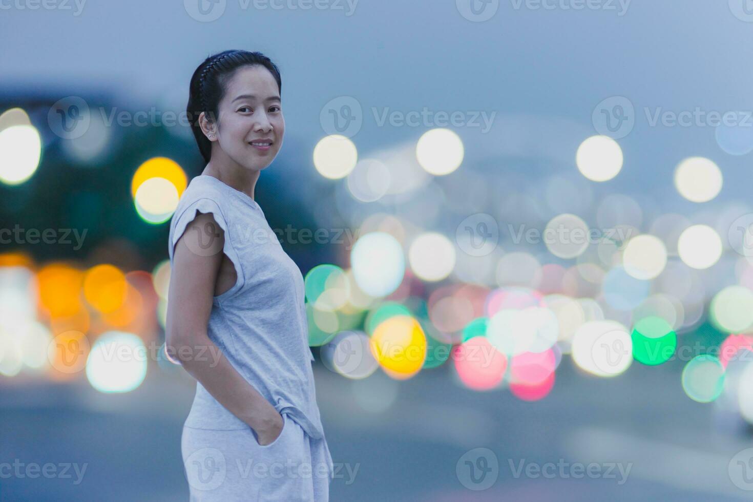 porträtt av Lycklig leende asiatisk kvinna med bokeh ljus i bakgrund. foto