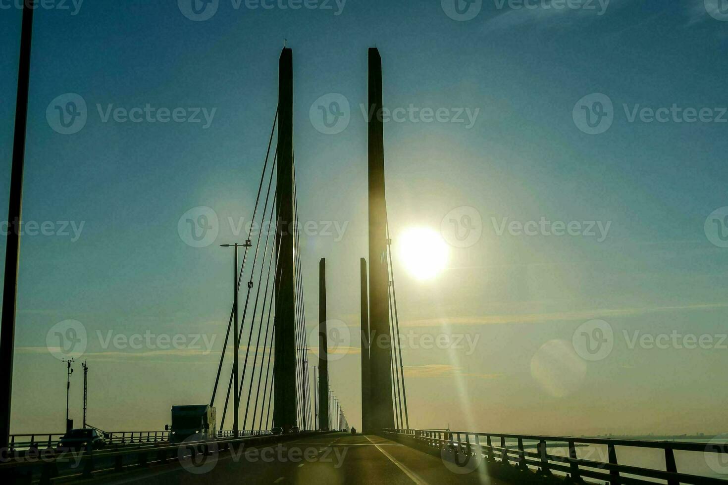 de Sol är lysande över en bro med två lång poler foto