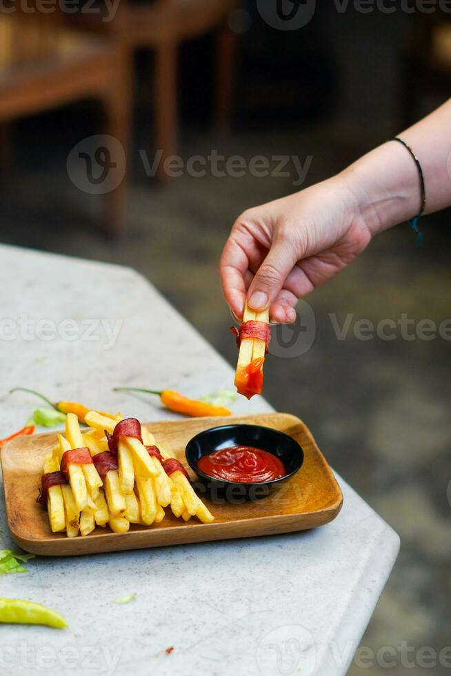 beskurna hand doppning potatis skiva till sås stänga upp foto