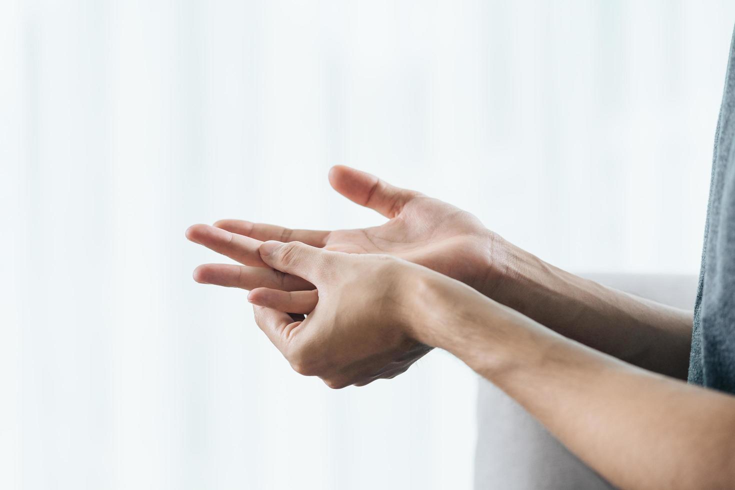 man som lider av hand och finger ledvärk, orsaker till reumatoid artrit, karpaltunnelsyndrom, gikt. hälsovård och medicinsk koncept. foto