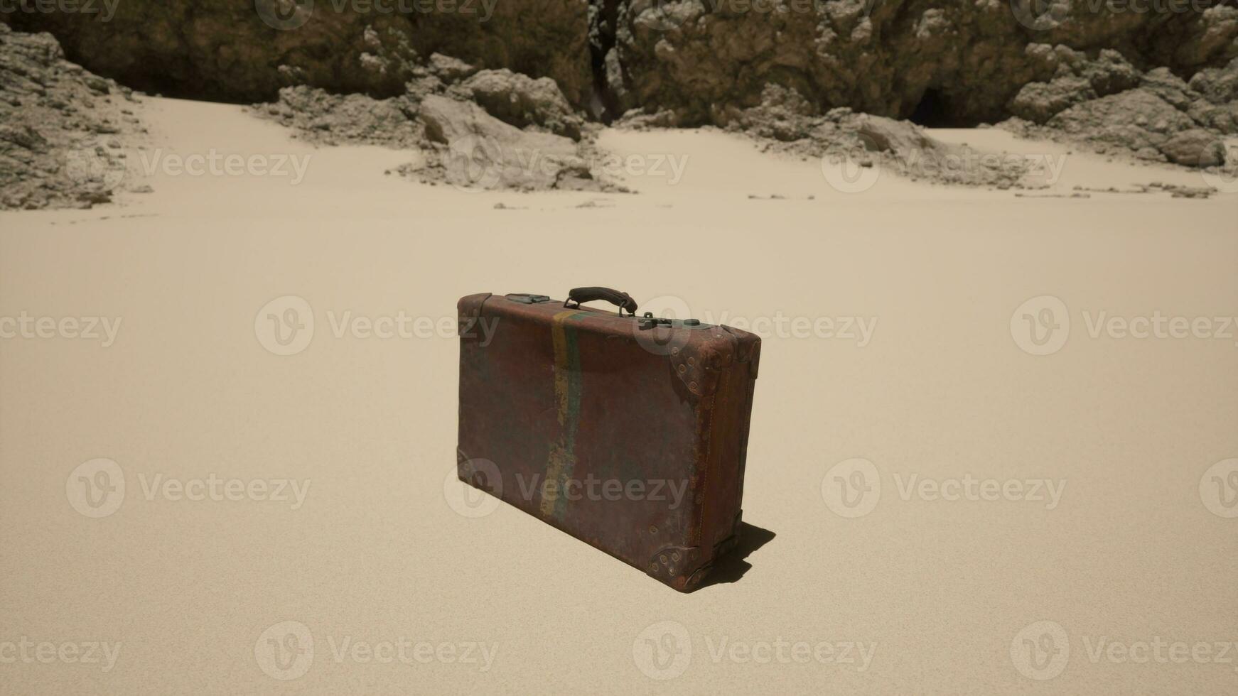 en bit av bagage Sammanträde på topp av en sandig strand foto