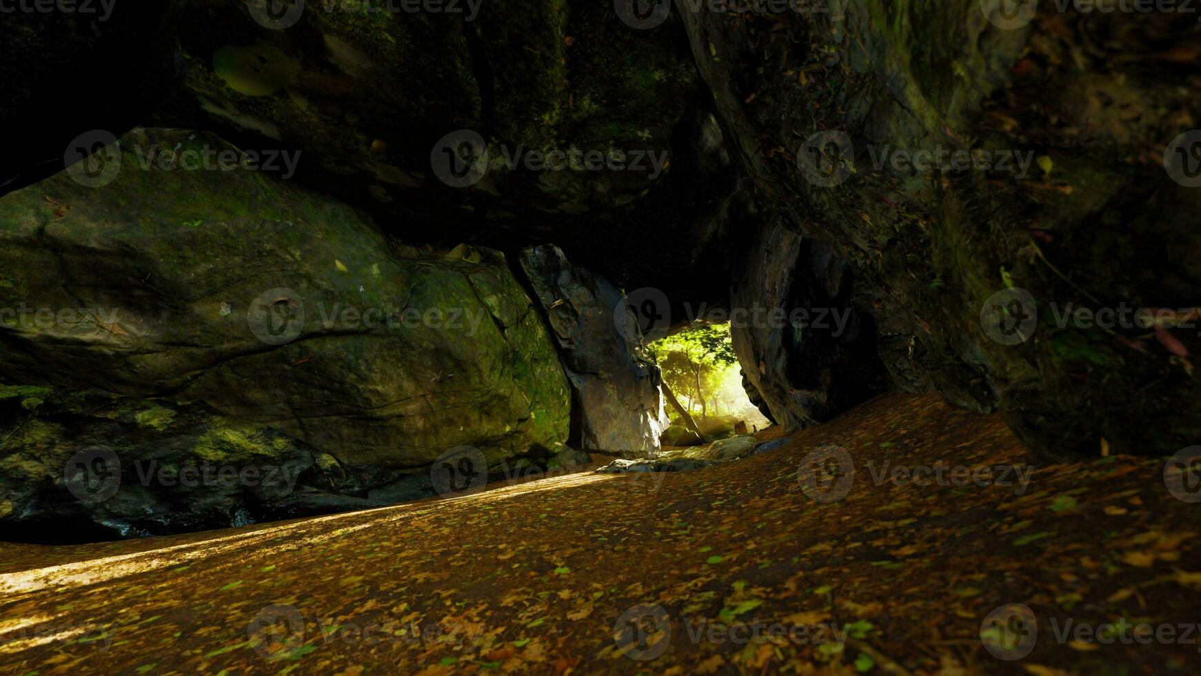 axel av ljus strålande ner in i stor grotta foto