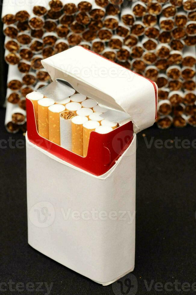 en packa av cigaretter Sammanträde på topp av en vit låda foto