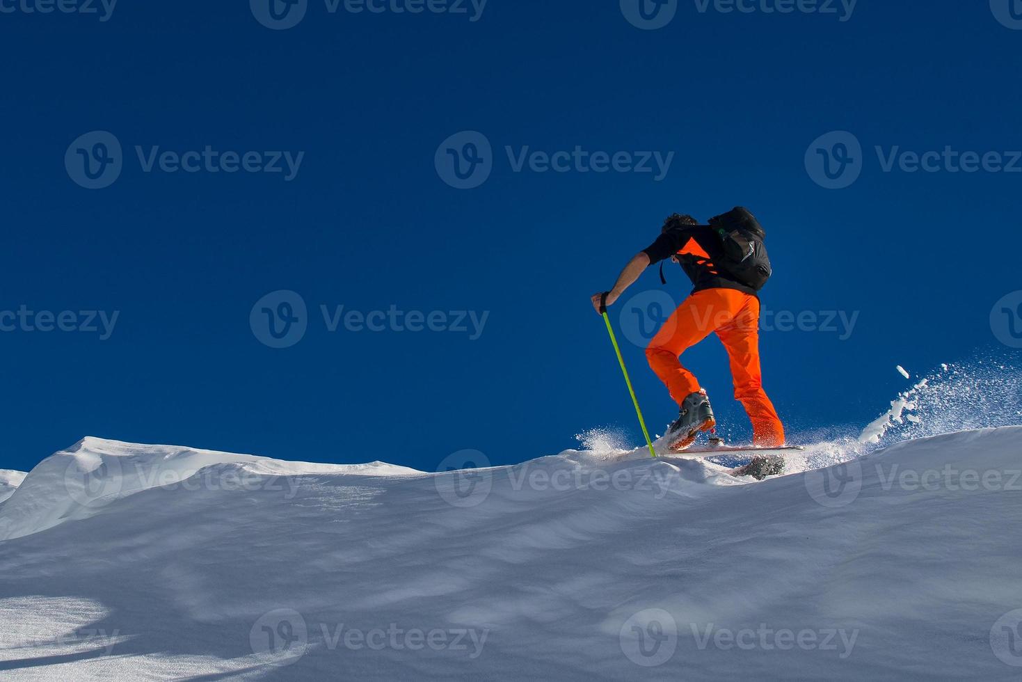 en man alpin skidåkare klättra på skidor och sälskinn foto