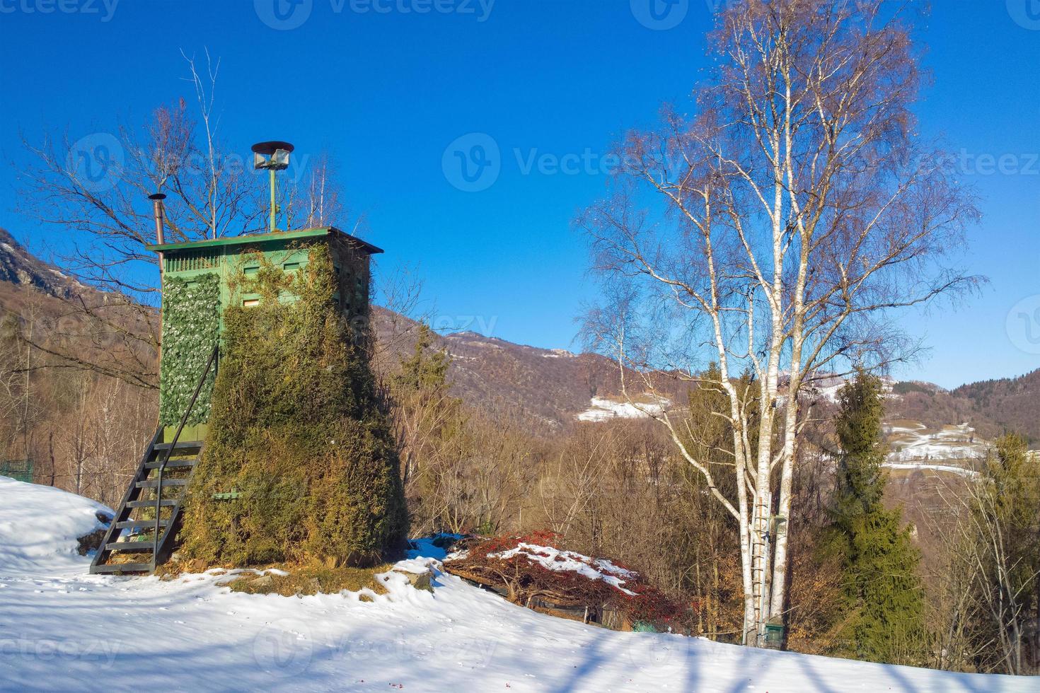 kamouflerad träkoja för jakt i bergen på vintern foto