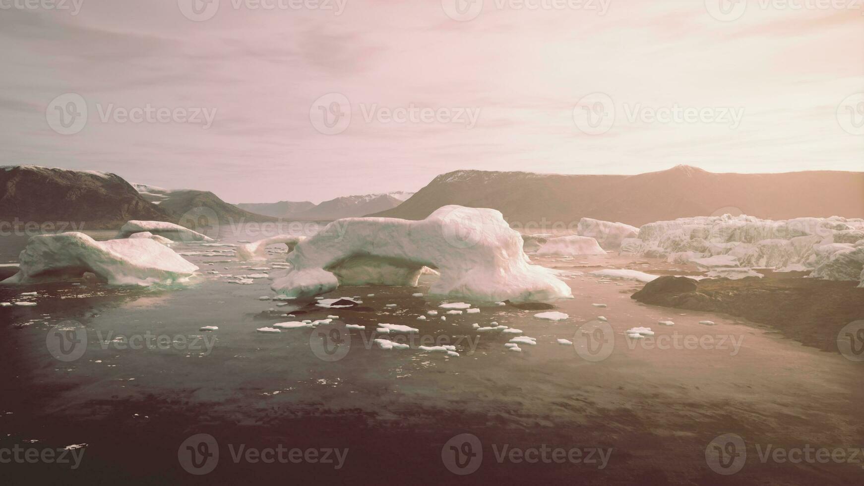 en lugn landskap med flytande isberg i en kristall klar kropp av vatten foto