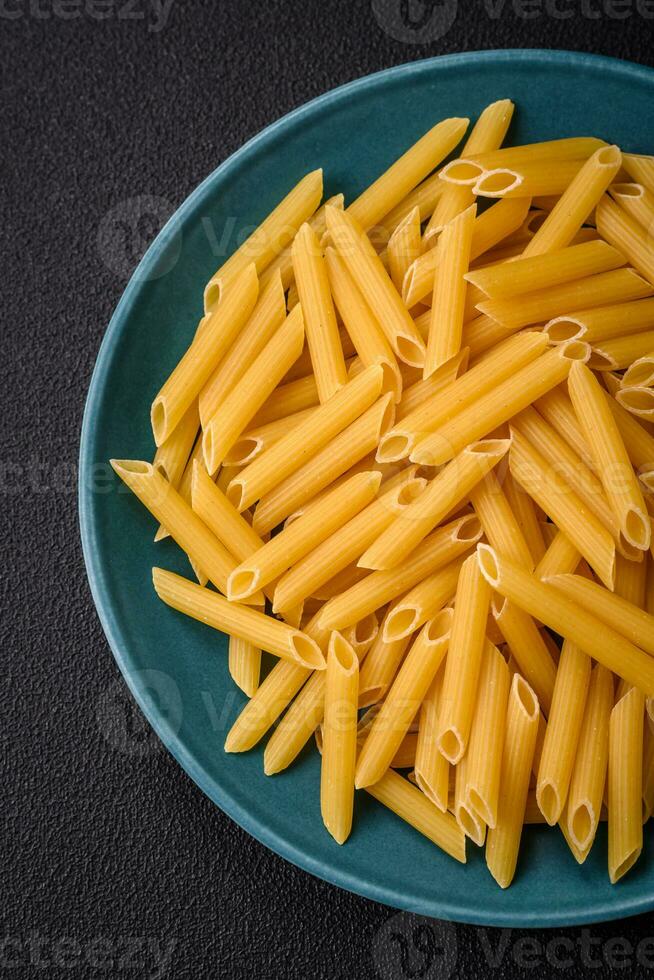 rå penne pasta från hela spannmål vete olika sorter med salt och kryddor foto