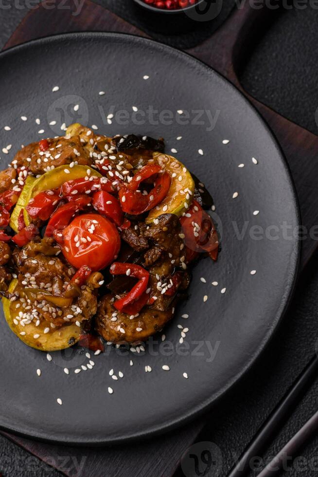 värma sallad med kalvkött, tomater, paprika, zucchini, sesam, salt, kryddor och örter foto