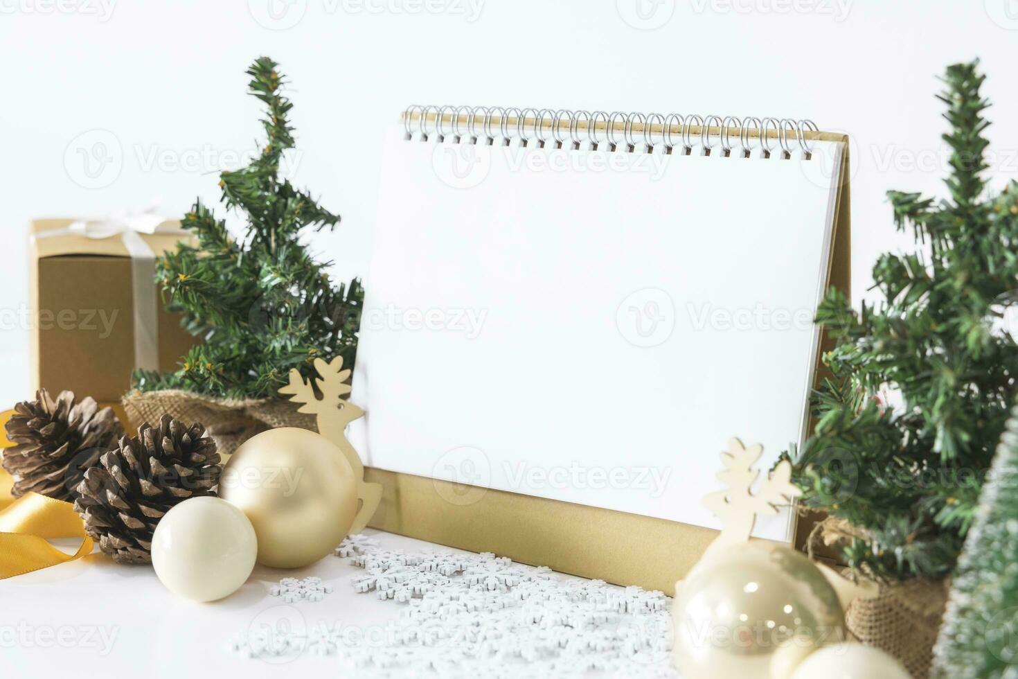 de vit kalender falsk upp till stiga på text förbi de festlig scen av skön jul träd Utsmyckad, med jul bollar, tall kottar, röd hus gåva låda bunden gyllene band. begrepp handla om Viktig dag. foto