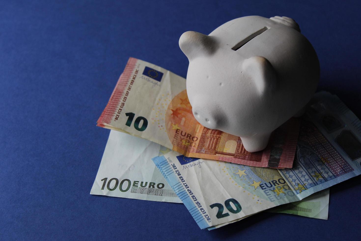 vit spargris på de europeiska sedlarna och blå bakgrund foto