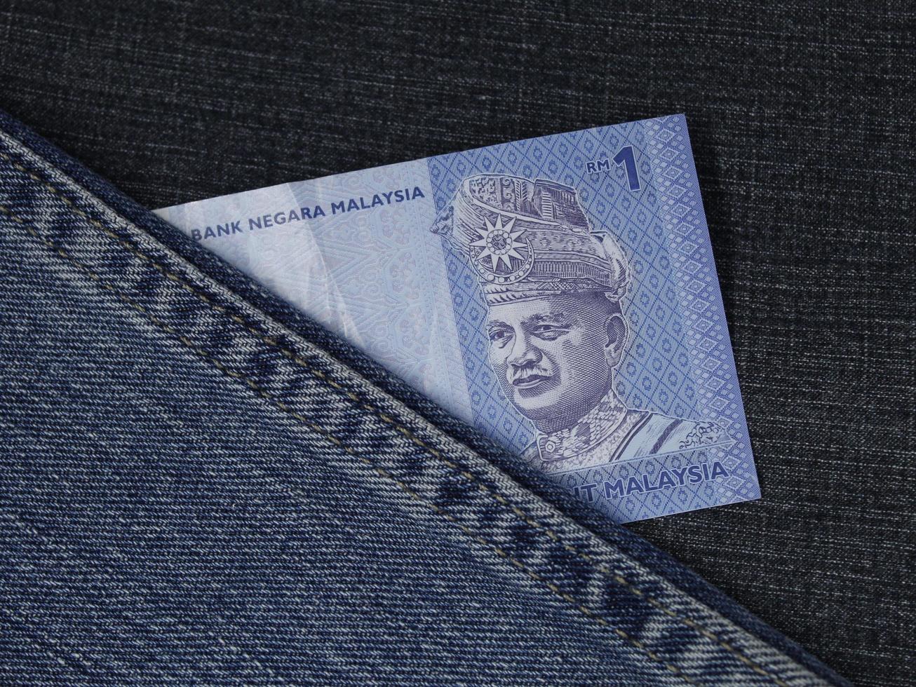 malaysisk sedel av en ringgit mellan blått denimtyg foto