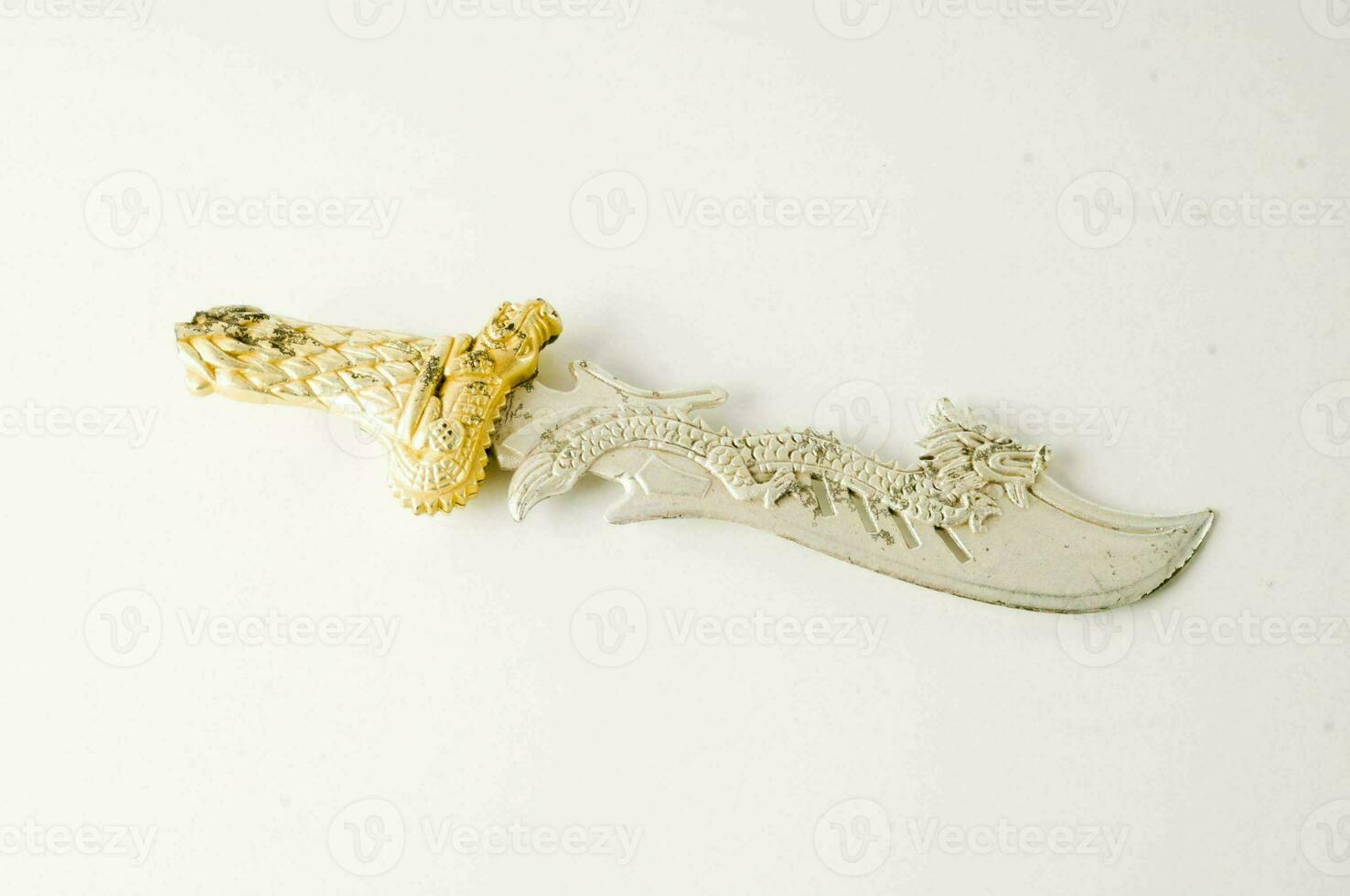 en silver- och guld kniv med en drake på den foto
