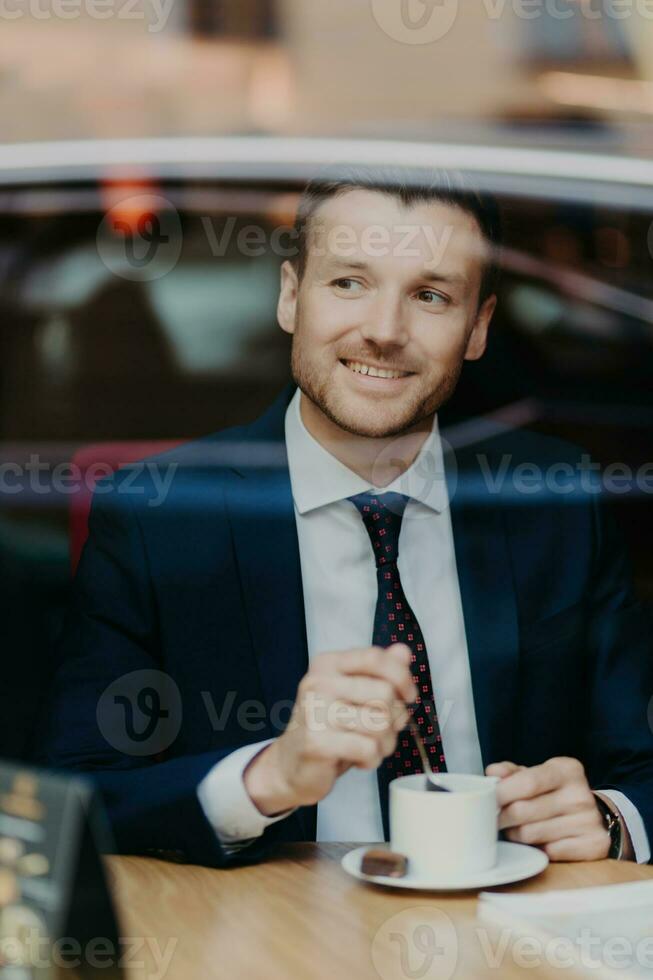 lugn affärsman njuter kaffe Bakom fönster, urban reflektioner, lugna ögonblick foto