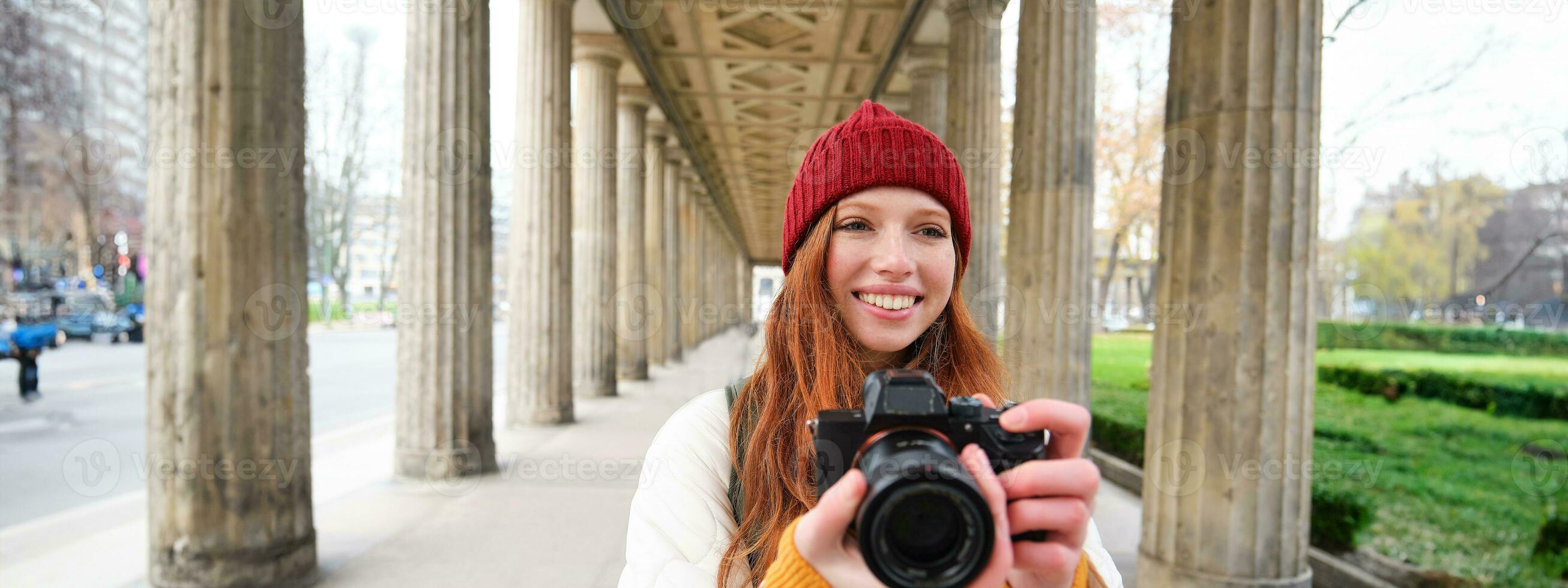 leende turist fotograf, tar bild under henne resa, innehar professionell kamera och gör foton