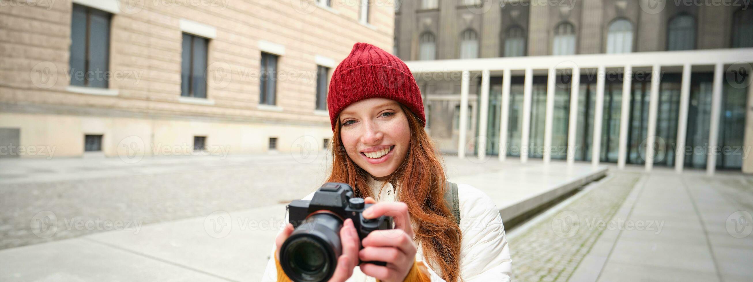 skön läshuvud flicka, fotograf med professionell kamera tar bilder utomhus, gående runt om stad och tar foton, sightseeing foto