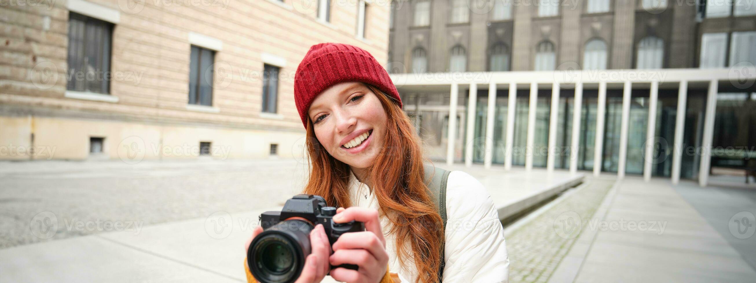 skön läshuvud flicka, fotograf med professionell kamera tar bilder utomhus, gående runt om stad och tar foton, sightseeing foto
