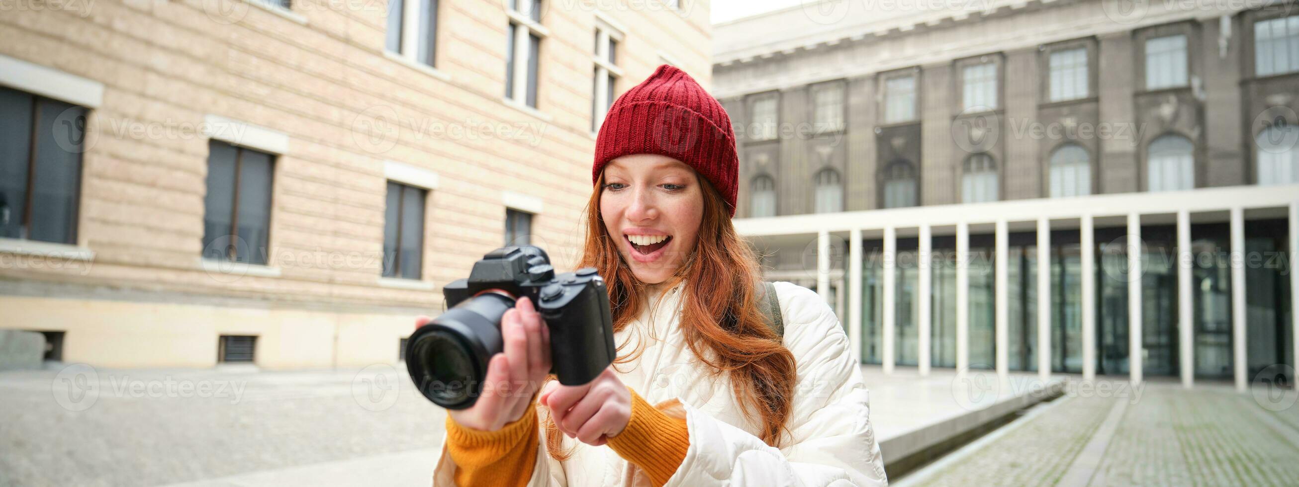 skön läshuvud flicka, fotograf med professionell kamera tar bilder utomhus, gående runt om stad och tar foton, sightseeing foto