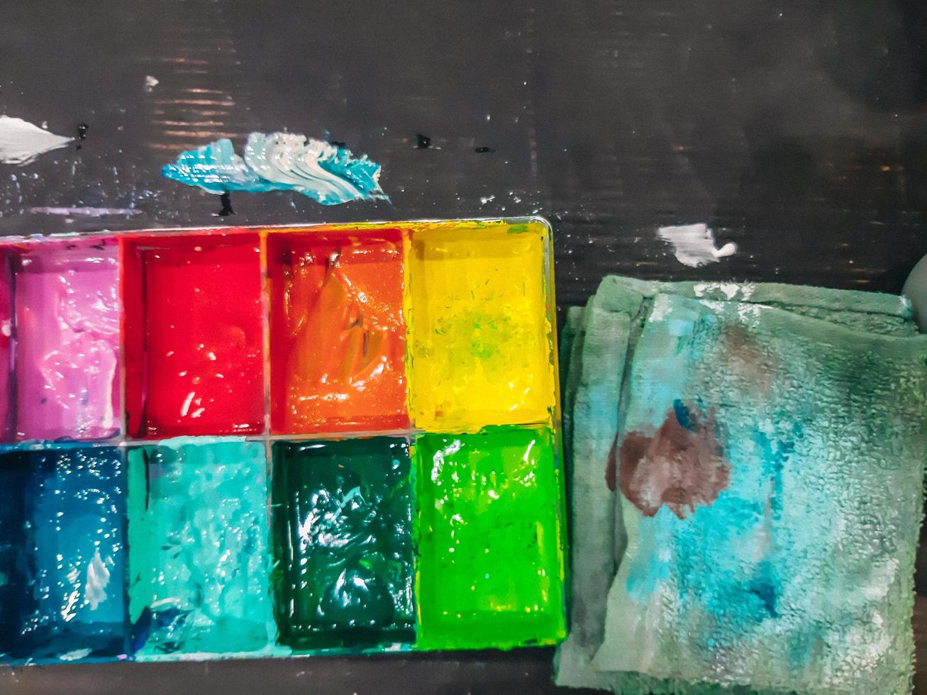 akvarell i en palett, paletten vatten målar på bordet, många färger i paletten vattenfärger foto
