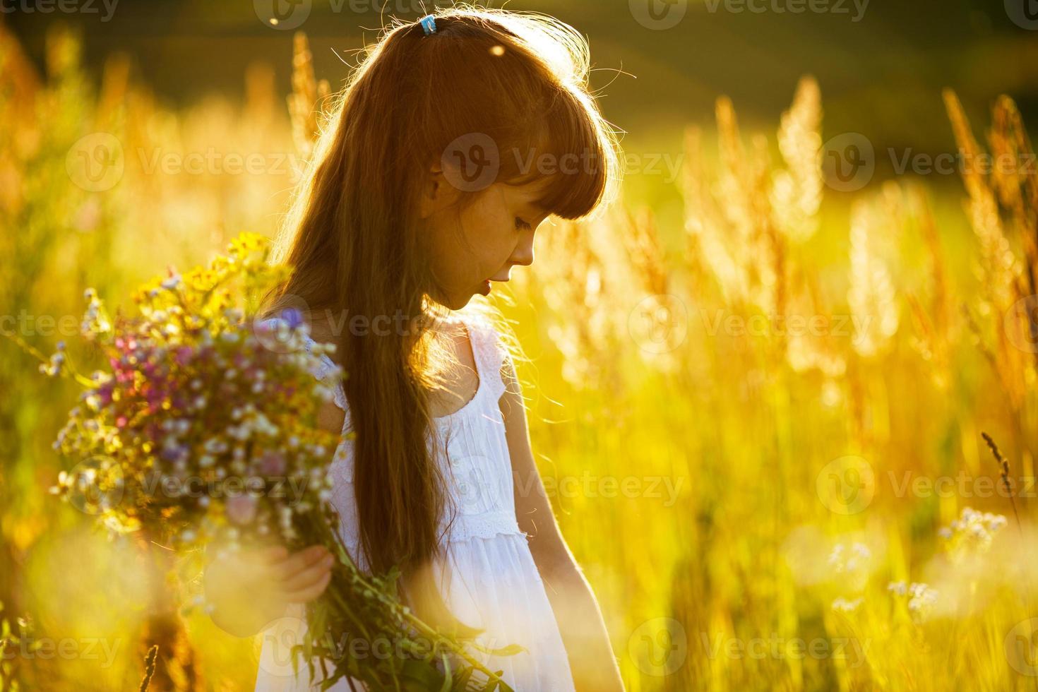 flicka med en bukett vilda blommor foto