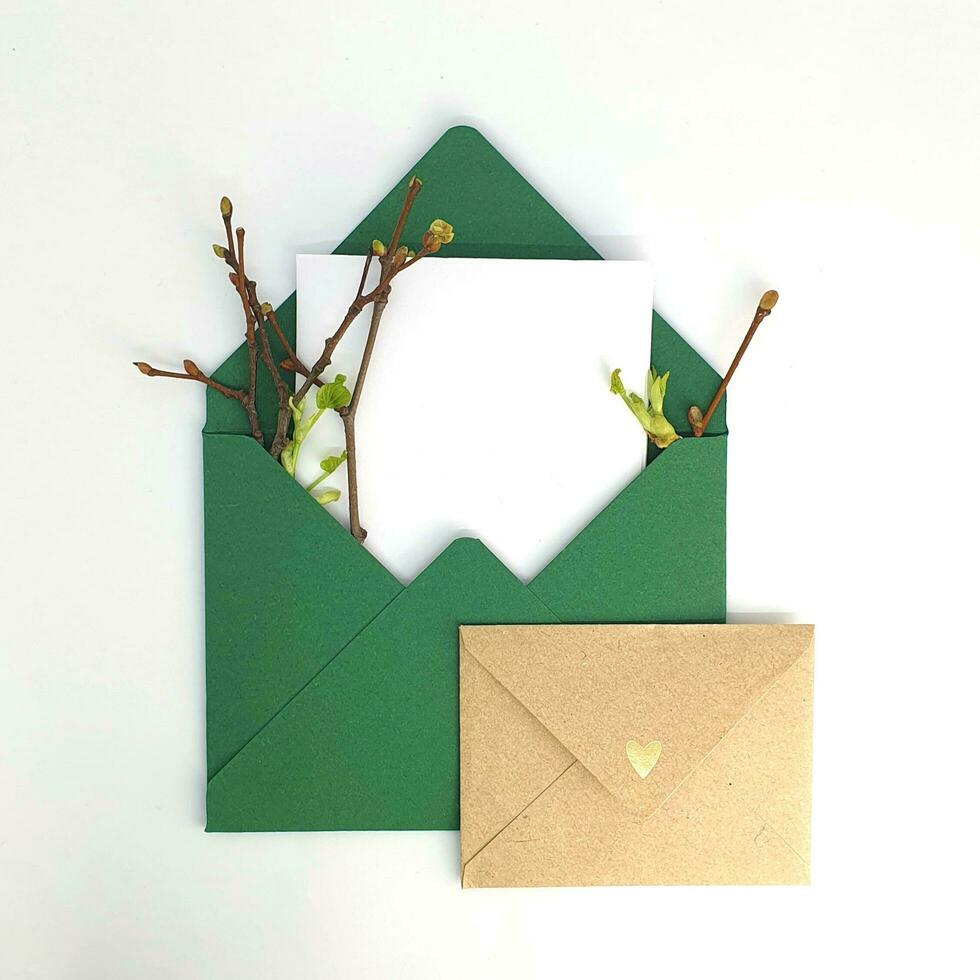 två kuvert med Plats för text. vår inbjudan. kuvert med kvistar och löv. hantverk papper foto