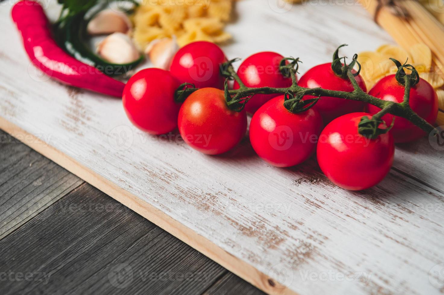 välsmakande aptitretande italienska spaghetti pasta ingredienser för kök med tomat, ost parmesan, olivolja, fettuccine och basilika på träbrunt bord. mat italienskt recept hemlagat. toppvy foto