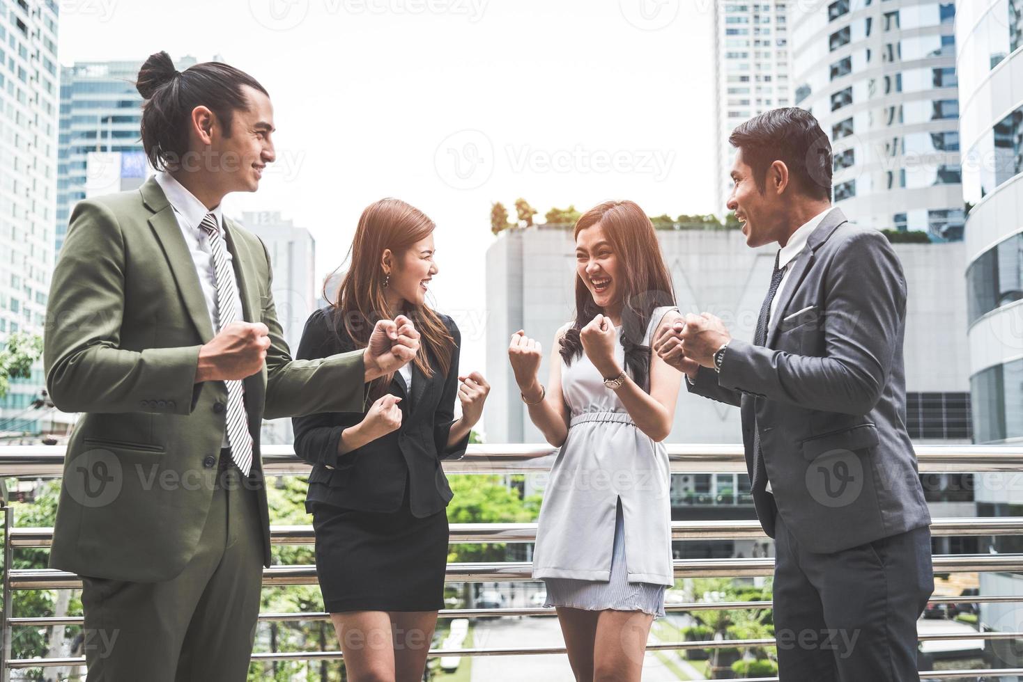 porträtt av framgångsrik grupp affärsmän på utomhus urban. glada affärsmän och affärskvinnor som lyfter handen som team i tillfredsställelse gest. framgångsrik grupp människor leende efter prestation foto