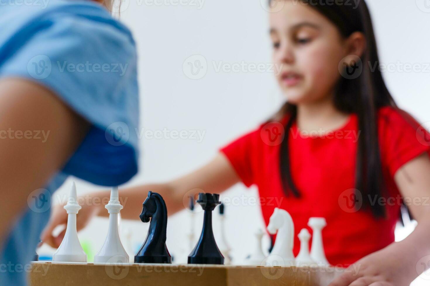 två söta barn som spelar schack hemma foto