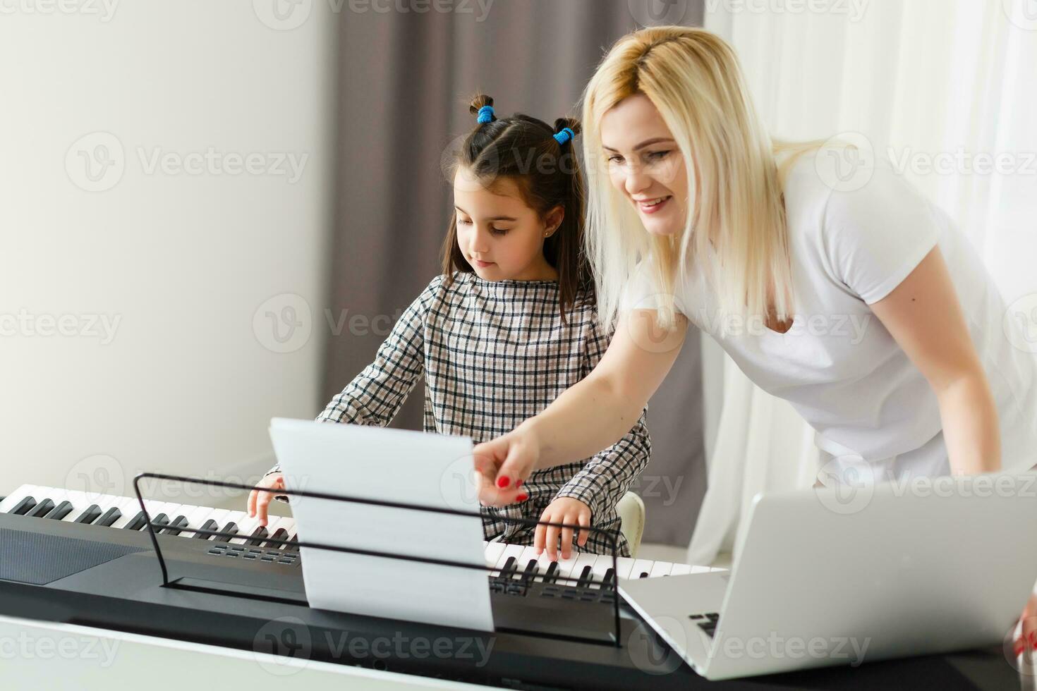 söt liten flicka spelar på piano, synthesizer. Träning. utbildning. skola. estetisk Träning. elementärt klassrum. foto