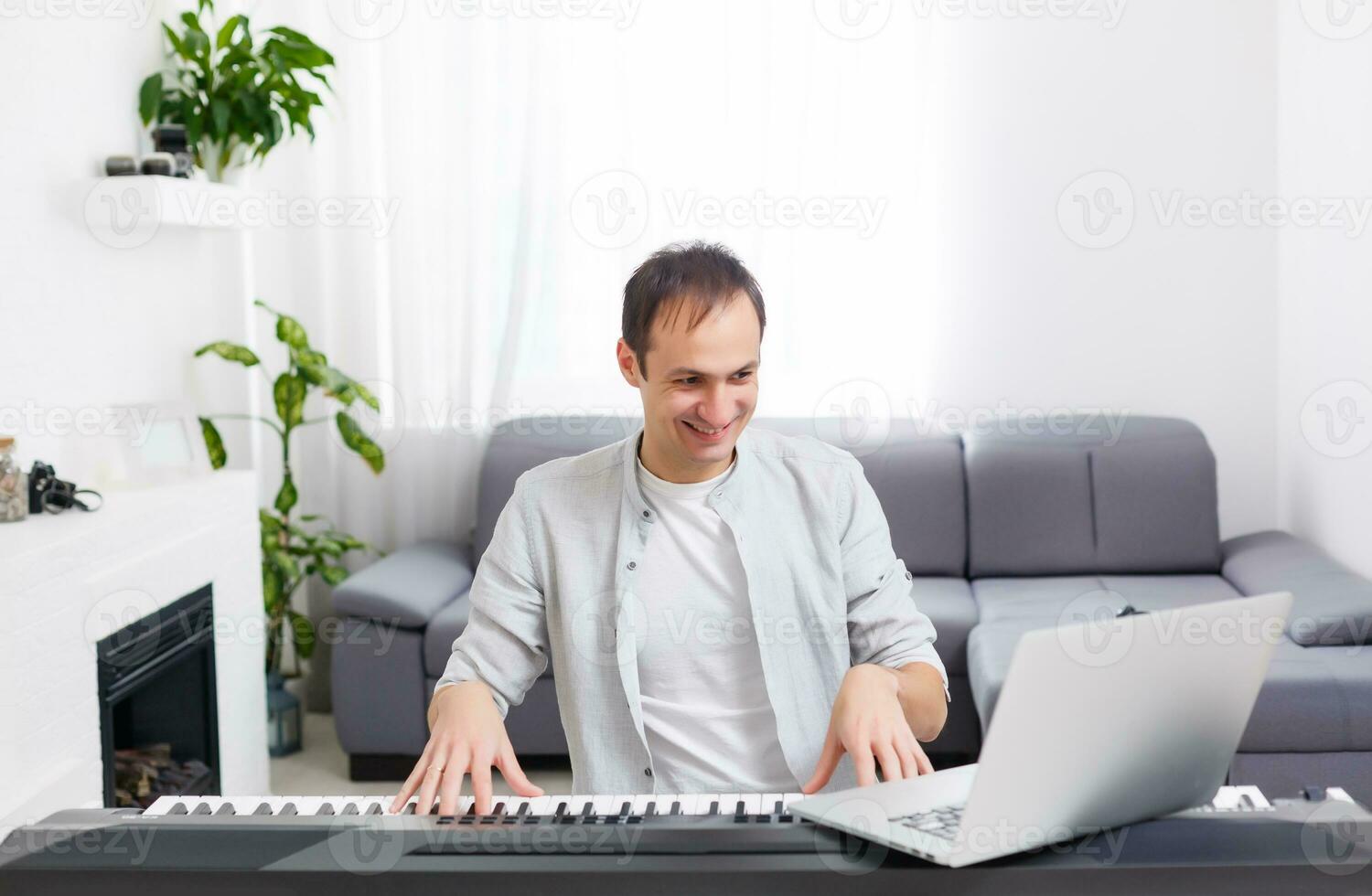 man spelar musik med piano och bärbar dator foto