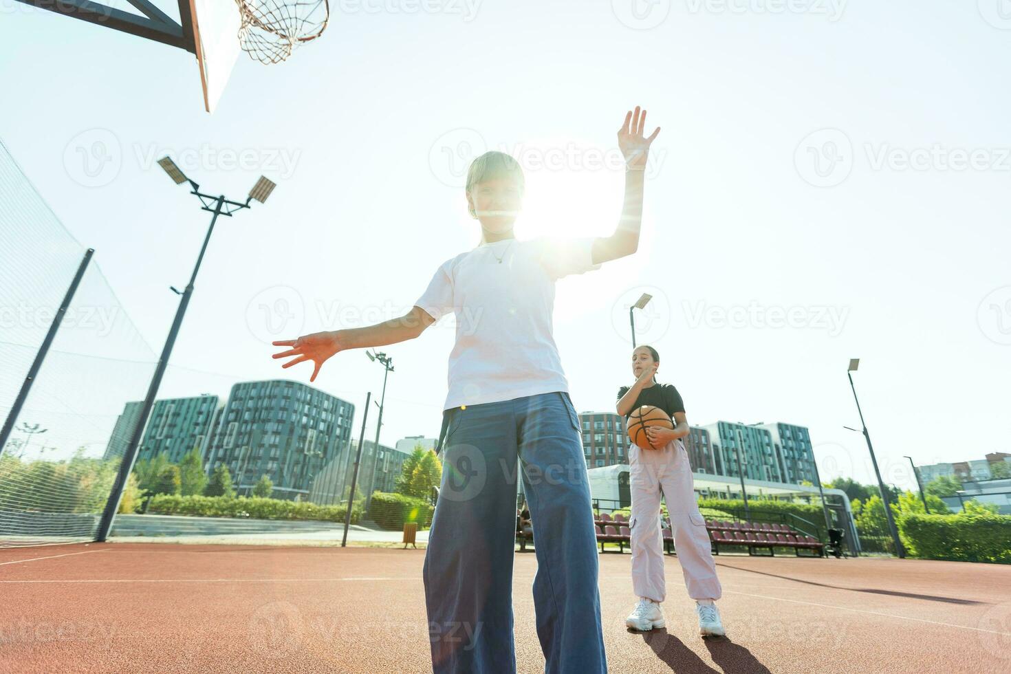 barn och sporter. Tonårs flicka spelar basketboll på de lekplats. foto