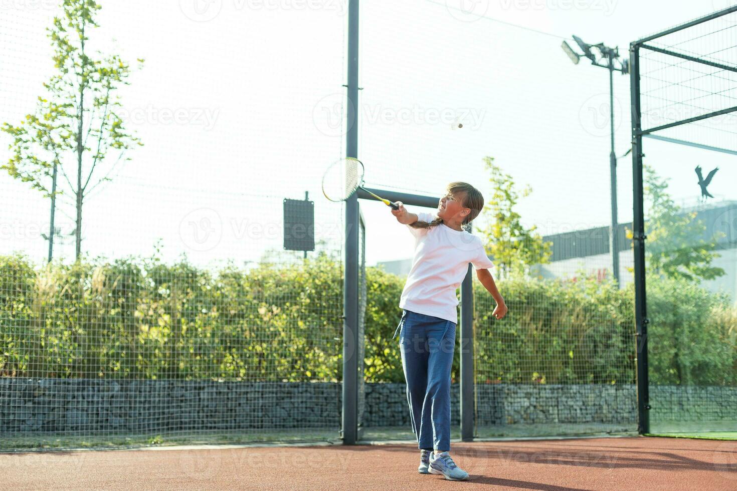 trevlig flicka med racket i händer spelar spel av tennis foto
