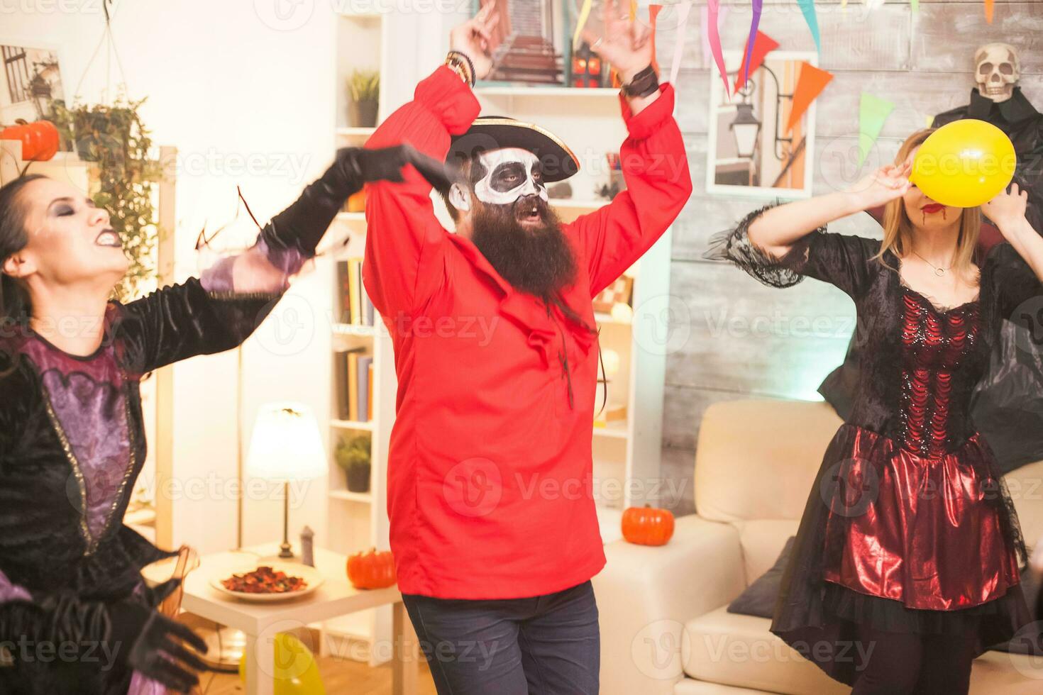 man klädd upp tycka om skäggig pirat dans med händer upp medan fira halloween. foto