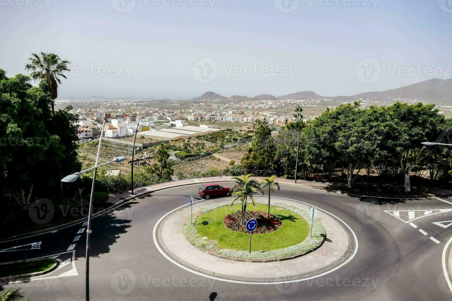 en rondell i de mitten av en stad med en bil körning runt om den foto