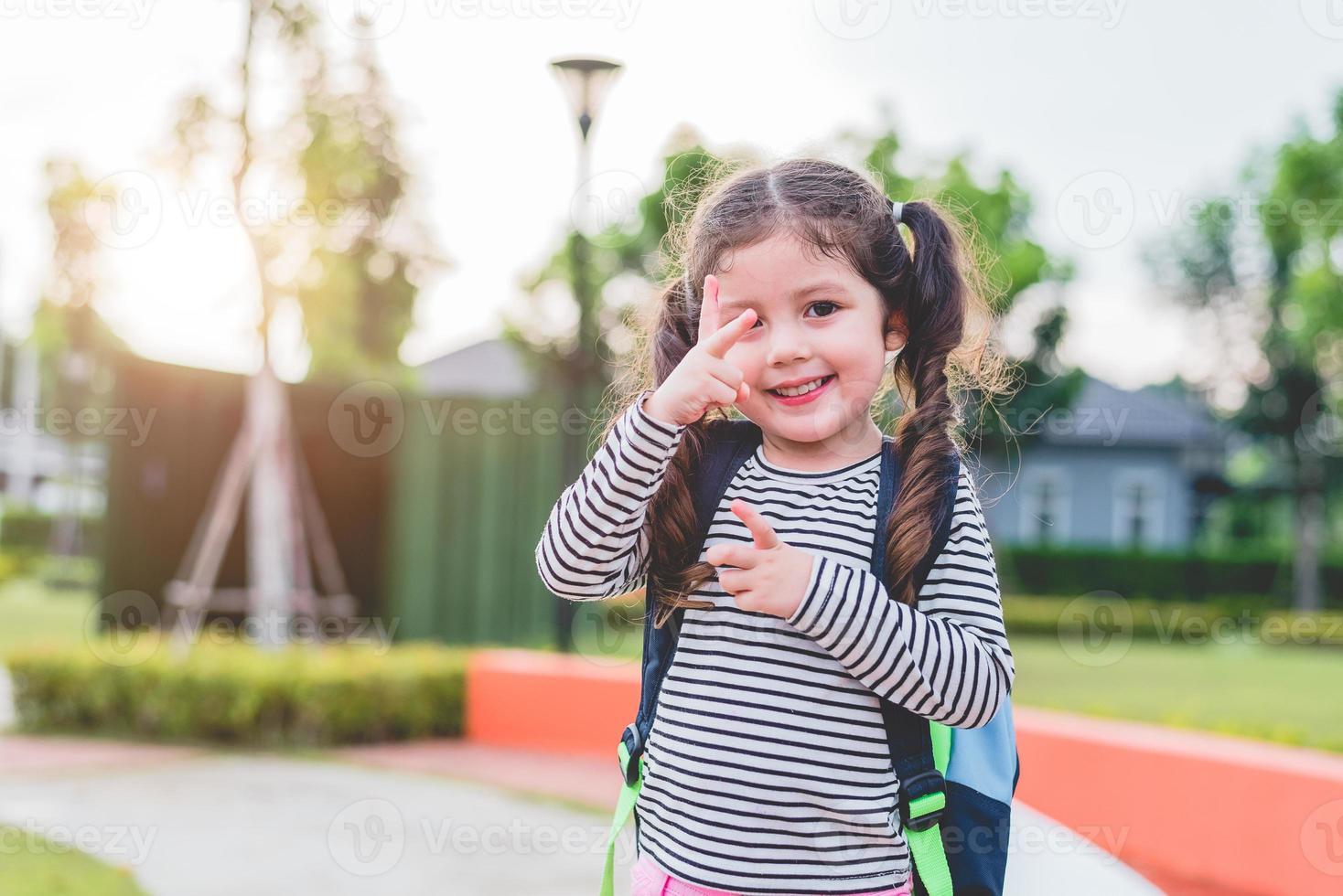 glad liten flicka tycker om att gå till skolan. tillbaka till skolan och utbildning koncept. lyckligt liv och familjen livsstil tema foto
