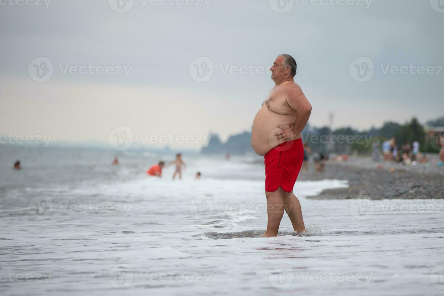 ett övervikt äldre man är vilar på de hav. foto