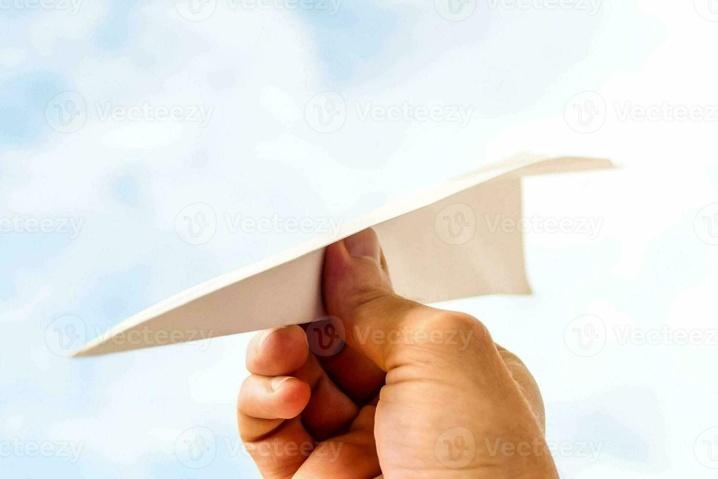 en person innehav en papper flygplan foto