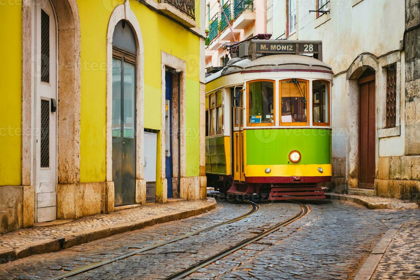 känd årgång gul spårvagn 28 i de smal gator av alfama distrikt i Lissabon, portugal foto