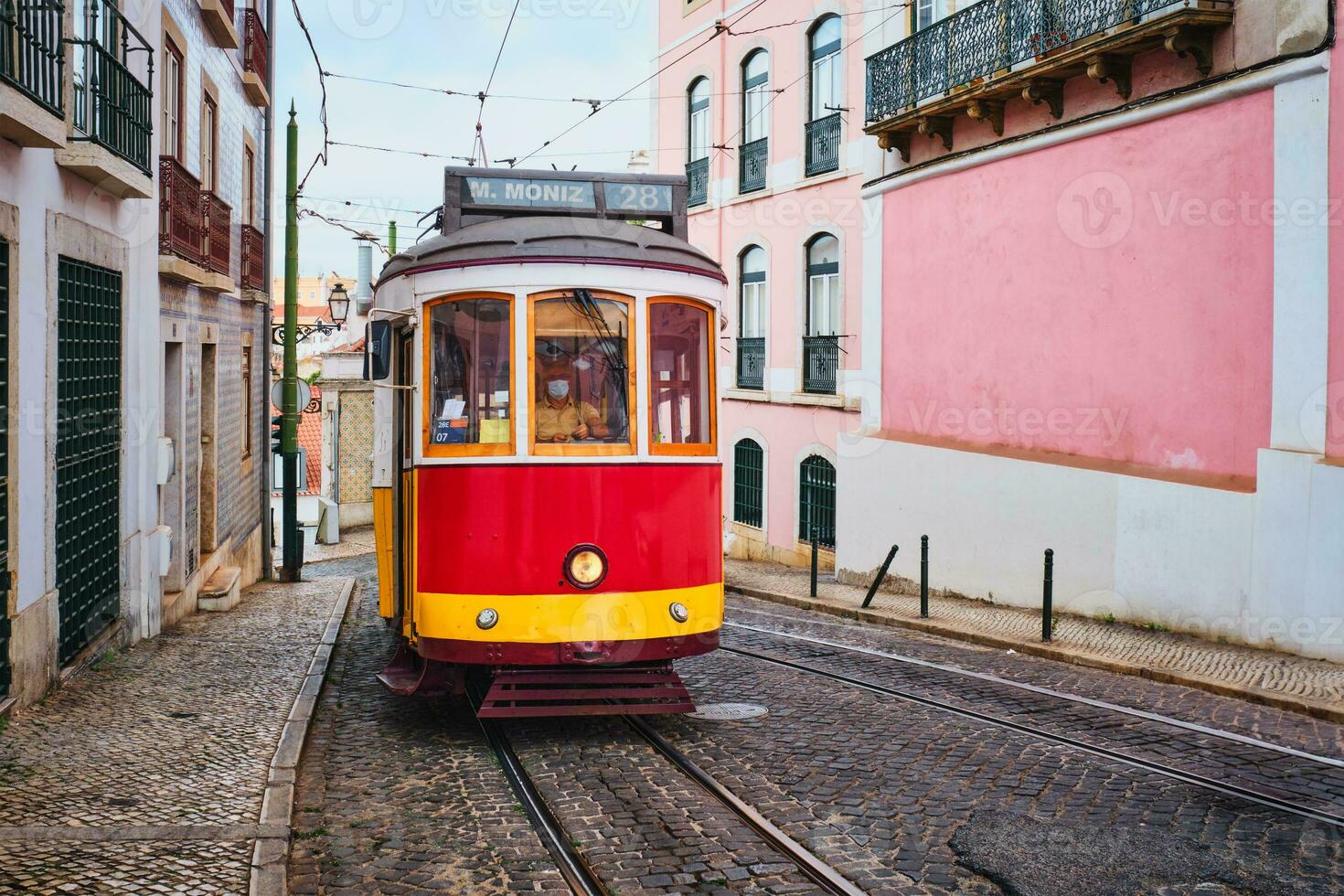 känd årgång gul spårvagn 28 i de smal gator av alfama distrikt i Lissabon, portugal foto